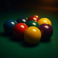 Set of glossy billiard balls racked on green cloth