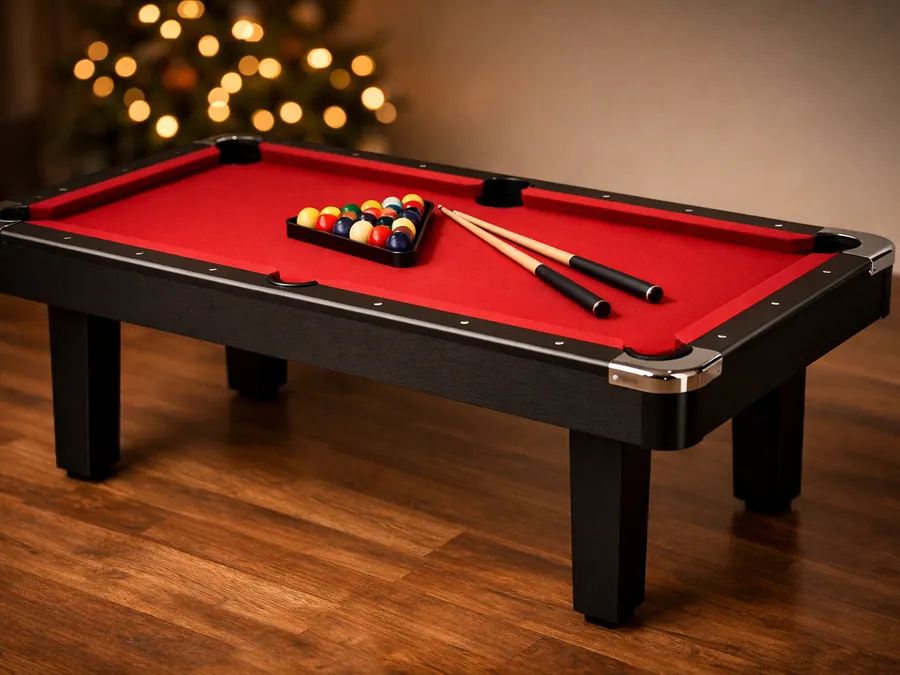 A compact six-foot pool table with red felt and chrome corners in a game room